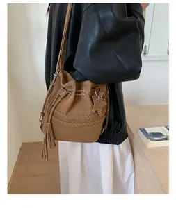 Λεπτομέρεια καφέ vintage τσάντα bucket με πλεκτό σχέδιο και κρεμαστό αστέρι με φούντα
