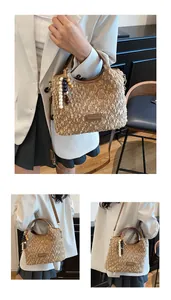 Dettaglio borsa in tweed con manici in pelle e ciondolo decorativo con perline