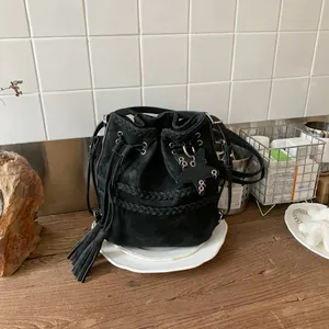 Μίνιμαλ μαύρη τσάντα bucket με κορδόνι, πλεκτές λεπτομέρειες και κομψά κρόσσια