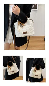 Dettaglio borsa tote in peluche bianca con finiture in pelle marrone e nappa di perline