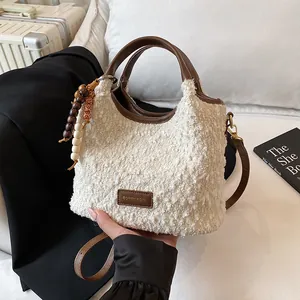 Borsa a secchiello in pile bianco con finiture in pelle marrone e tracolla