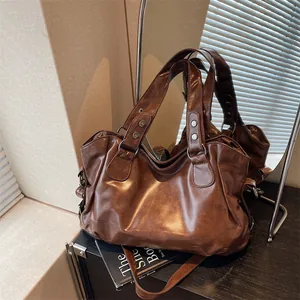 Μεγάλη σκούρα καφέ vintage τσάντα tote με μεταλλικά καρφιά σε κομψή αντανάκλαση καθρέφτη