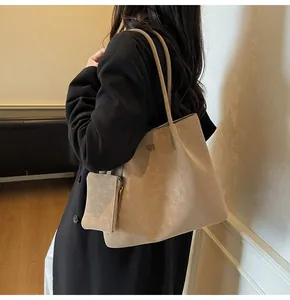 Detail of beige faux leather tote bag with COIN SON logo and matching small zipper pouch