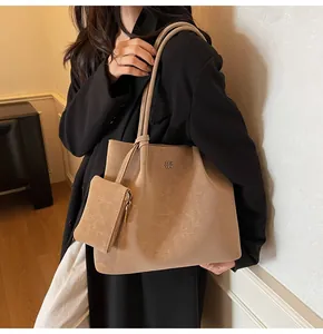 Detail of camel brown faux leather tote bag with brand logo and small coin purse