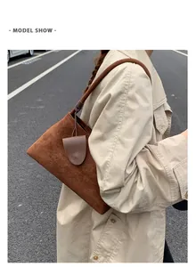 Detailed side view of a brown suede hobo bag shown on model for style and size