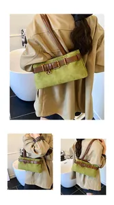 Detail van vintage avocadogroene suède handtas met bruine leren riem en gouden gesp