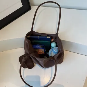 Large dark brown leather tote bag with interior view showing daily essentials and mini pouch