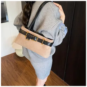 Détail du sac à main en daim kaki avec sangle noire et boucles métalliques dorées