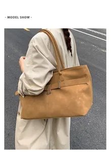 Street style λήψη μιας μεγάλης ρετρό τσάντας σε καφέ χρώμα με μεταλλική λεπτομέρεια