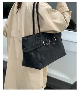 Λεπτομέρεια vintage μαύρης τσάντας tote με διακοσμητική ασημένια αγκράφα και ματ φινίρισμα