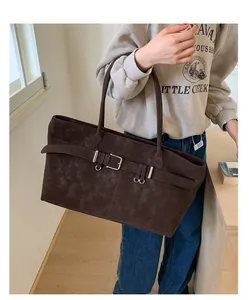 Λεπτομέρεια μεγάλης vintage τσάντας tote σε καφέ χρώμα με λουράκι και ματ υφή