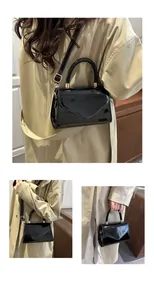 Détail du mini sac bandoulière en cuir verni noir brillant avec finitions dorées et anse