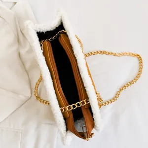 Innenansicht der braunen Plüschtasche mit Reißverschlussfach und goldener Kette