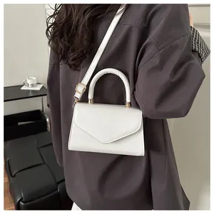 Détail du sac à main blanc en cuir brillant avec rabat enveloppe et dorures fines