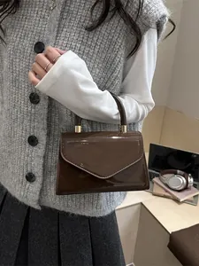 Petit sac à main marron brillant en cuir verni avec rabat triangulaire chic