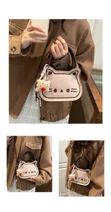 Detail of cute cat shaped mini crossbody bag with embroidery and plush charm pendant