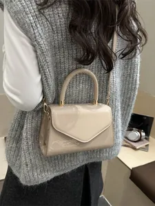 Mini sac bandoulière chic en cuir verni crème avec détails dorés et rabat triangle