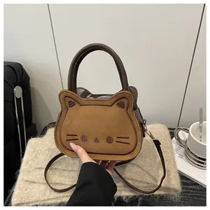 Close-up of brown suede bread cat crossbody bag with cute embroidered facial details