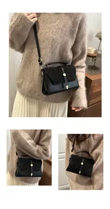 Detail of black crossbody bag with gold hardware and matte leather texture design