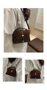 Detail of retro chocolate brown handbag showing suede flap and gold buckle hardware
