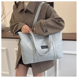 Dettaglio della borsa tote in lino azzurro con etichetta fashion e trama in tela spessa
