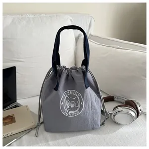 Macro detail of waterproof grey drawstring lunch bag with Panda logo and blue handles