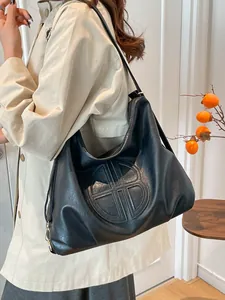 Vintage black large capacity hobo bag with round embossed logo and leather texture
