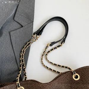 Detail of glitter brown fabric handbag with gold metal chain strap and leather shoulder pad