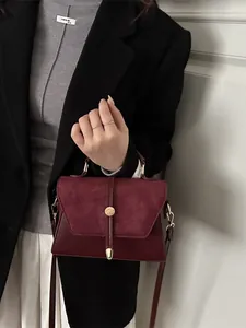 Burgundy faux leather shoulder bag with suede flap and elegant metal buckle detail