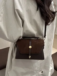 Deep brown crossbody square bag with velvet拼接 detail and golden buckle, shown on model