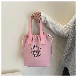 Close-up of pink drawstring lunch bag with bear print and sturdy woven ribbon handle