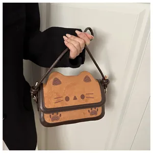 Close-up of a cute cat-themed crossbody bag with brown leather and ear-shaped flap detail
