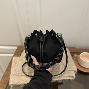 Sac seau chic en daim noir avec poignée tressée et fermeture à cordon pour femme