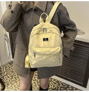 Detail of yellow star-patterned backpack showing canvas texture and adjustable straps