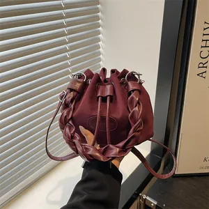 Sac seau chic en daim bordeaux avec poignée tissée pour femme à l'épaule