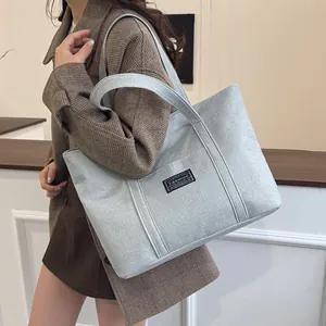 Borsa tote minimalista in lino azzurro con etichetta moda indossata da una modella