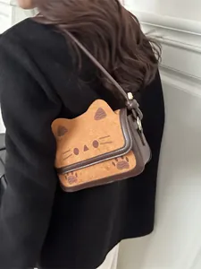 Chic cat-shaped crossbody bag in brown and khaki leather, shown on a model