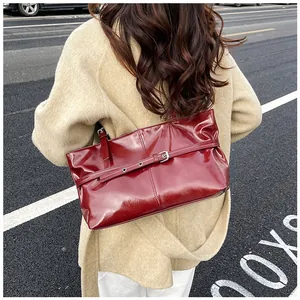 Vue street style d'un sac à épaule en cuir verni bordeaux sur un manteau en laine
