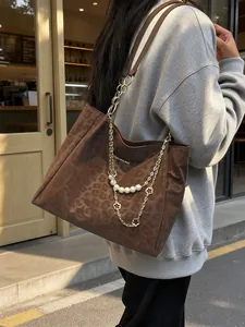 Brown leopard print tote bag with gold chain and pearls shown on model in street setting
