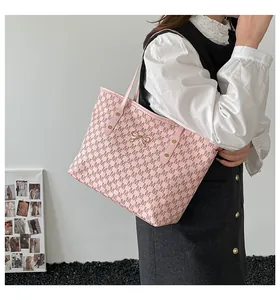 Detail view of pink tote bag with letter M pattern and gold bow-knot metal clasp buckle