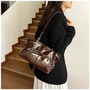 Détail du sac cabas marron foncé brillant avec boucles et bandoulière réglable