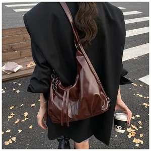 Streetstyle-Ansicht einer großen braunen Hobo-Tasche aus glänzendem Öl-Wachs-Leder