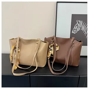 Detail view of stylish tote bags in beige and dark brown with elegant floral silk scarves