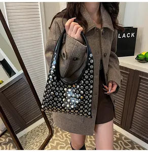 Close-up of black hobo bag featuring silver rivets and glossy leather texture