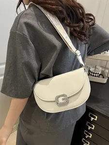 Creamy white crossbody saddle bag with G-shaped silver buckle and jacquard shoulder strap