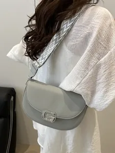 Light gray textured leather crossbody bag with wide geometric strap and silver G buckle