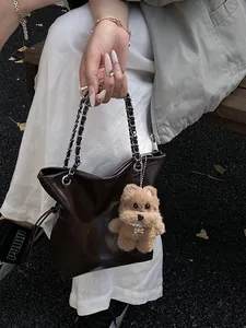 Borsa a secchiello in pelle marrone con catena d'argento e ciondolo a cagnolino