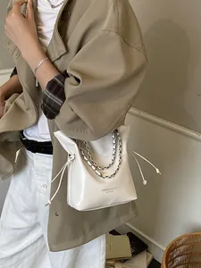 Secchiello in pelle verniciata bianca con catena d'argento e trench coordinato