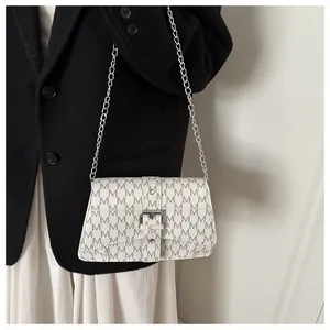 Detail of white monogram chain bag with silver buckle and grey M-pattern print