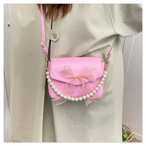 Sac bandoulière rose en cuir PU avec nœud organza et poignée perle sur modèle